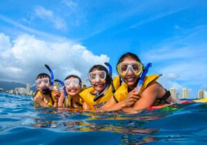 people wearing snorkeling masks and life vests snorkeling in oahu