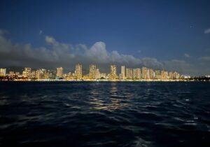 The city of Honolulu at night seen from the water